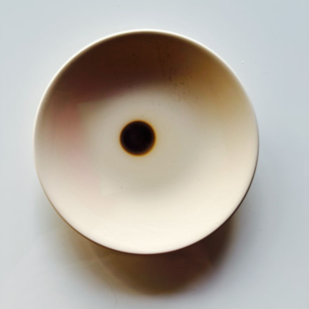 Ceramic incense dish with a visible burn mark from a used incense cone.