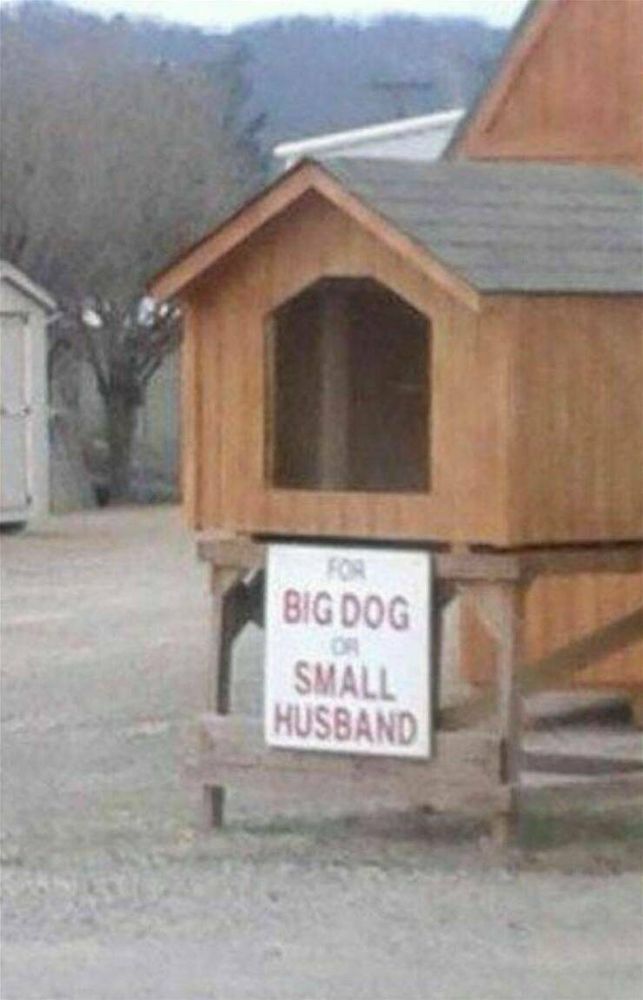 A dog house that has a sign that say for big dog or small husband