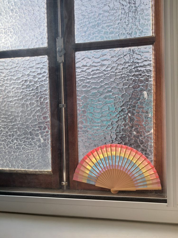 my gay little rainbow fan behind a frosted window 