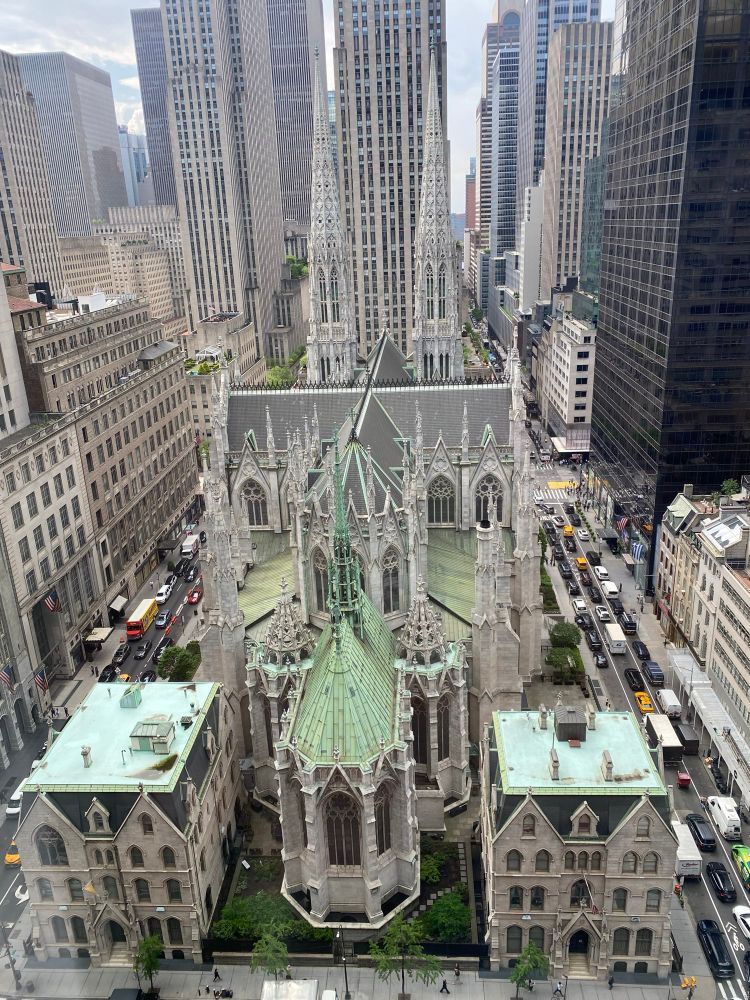 The back of Saint Patrick’s cathedral from above, with grey stonework, verdigris roofs and twin spires. NYC. 