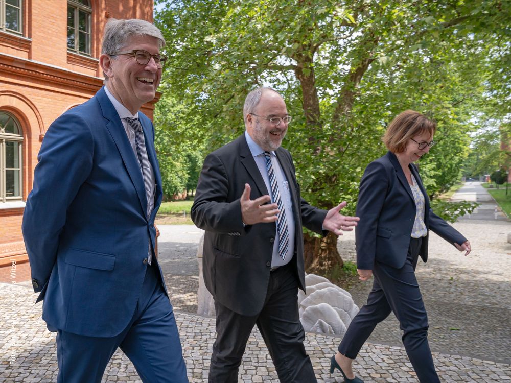 Wolfram Weimer läuft mit Bundesarchiv-Präsident Michael Hollmann und Vizepräsidentin Andrea Hänger bestens gelaunt über den Hof des Bundesarchivs in Berlin-Lichterfelde.
