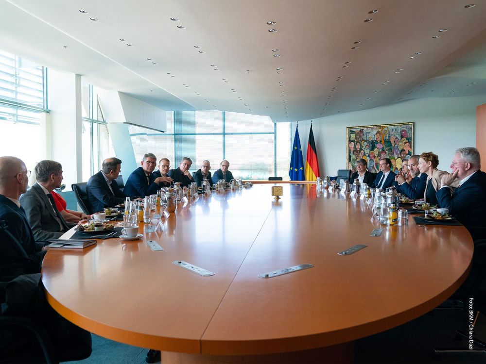 Vertreterinnen und Verteter von Kultureinrichtungen sitzen am Tisch des kleinen Kabinettsaales mit Staatsminister Wolfram Weimer.