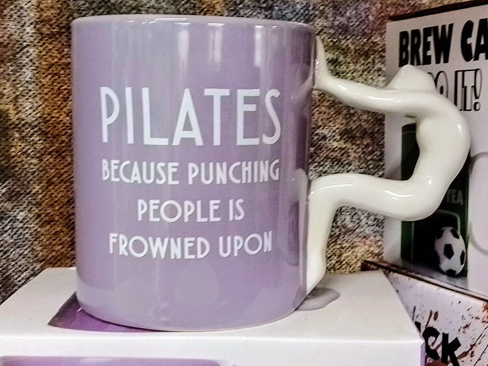 Mug with handle as woman doing downward dog. Lettering: Pilates because punching people is frowned upon.