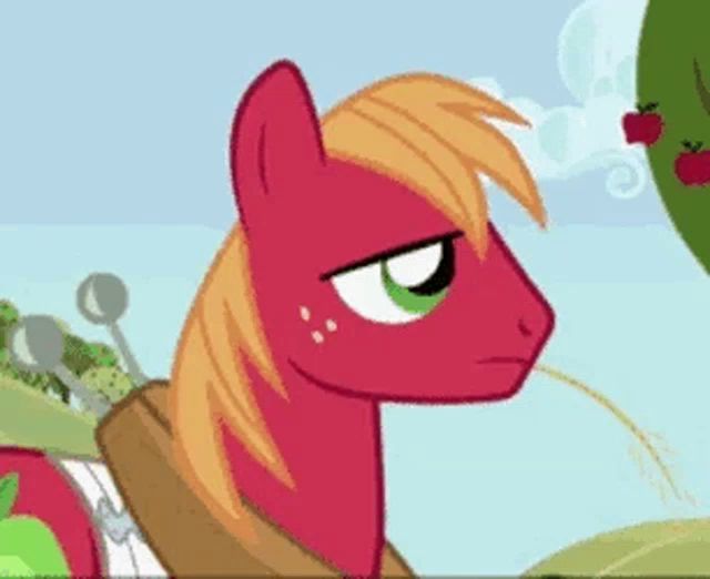 a red pony with a green eye is standing next to an apple tree and a spoon .