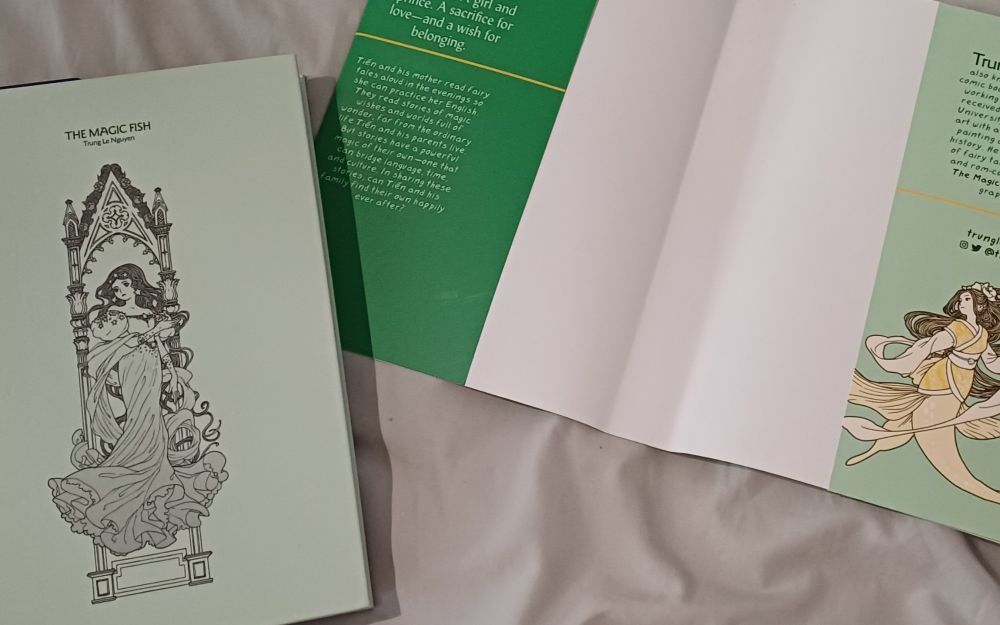 Hardback copy of "The Magic Fish" by Trung Le Nguyen, sans dust cover, revealing a beautiful secret illustration.