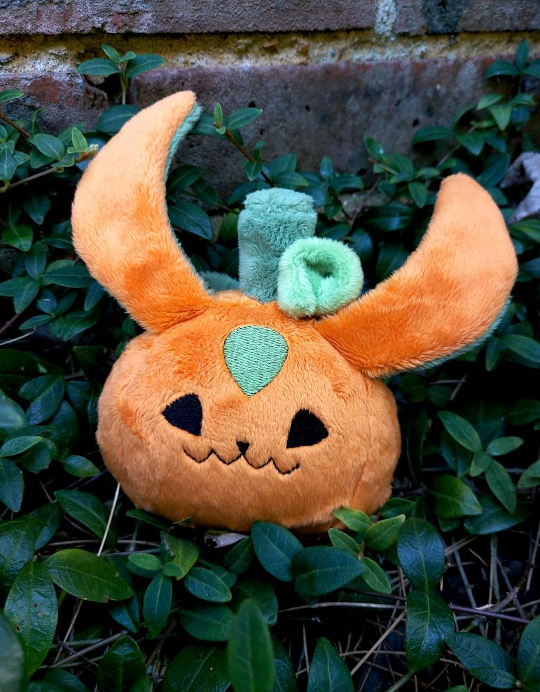 a photo of an orange carbuncle dumpling made to look like a jack o'lantern