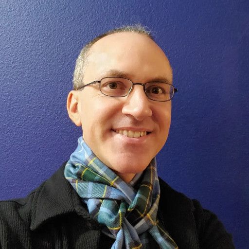 David Drake wearing a blue-and-green scarf and black jacket