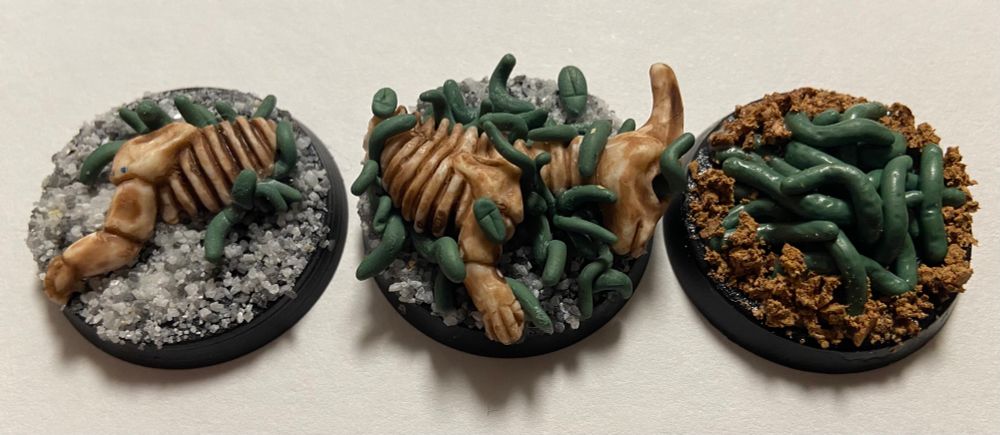 Three hand sculpted/converted miniatures, unpainted, depicting swarms of maggots, grubs, and other bugs, to be used as insect swarms in a Dungeons and Dragons campaign.