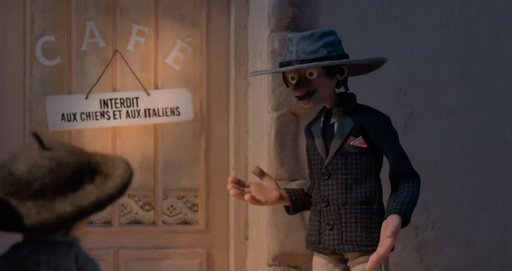 Screenshot of No Dogs Or Italians Allowed. It's a stop motion film. A man and his son in front of a café's door with a sign that says, in French, the title of the film.