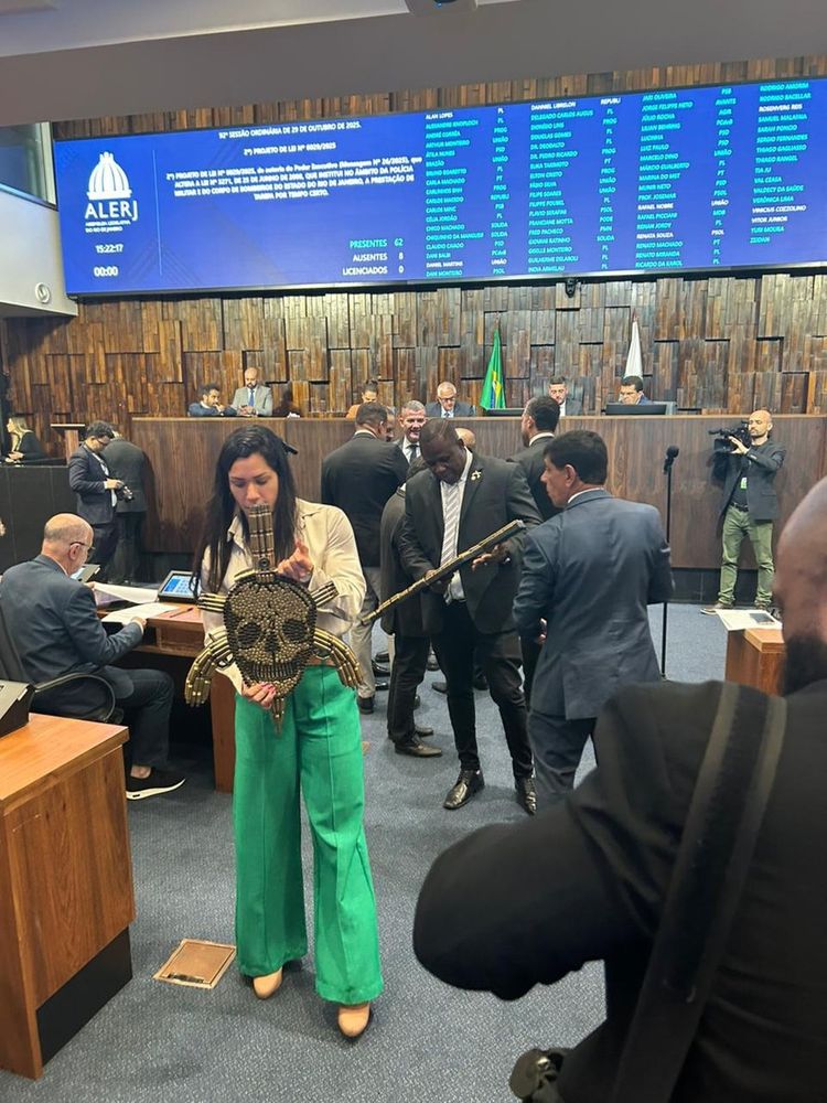 Deputados segurando caveira feita de balas e algo imitando fuzil 