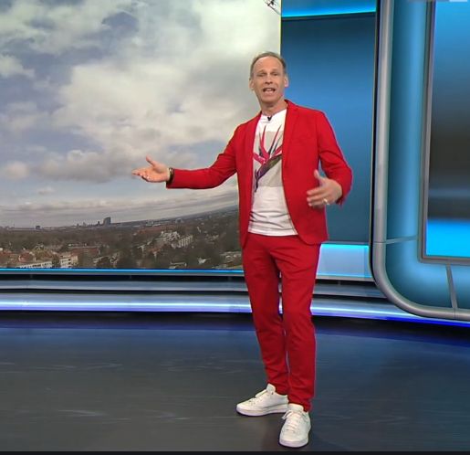 Marcus Wadsak moderiert das Wetter in knallrotem Anzug, weißen Sneakers und weißem T-Shirt. 