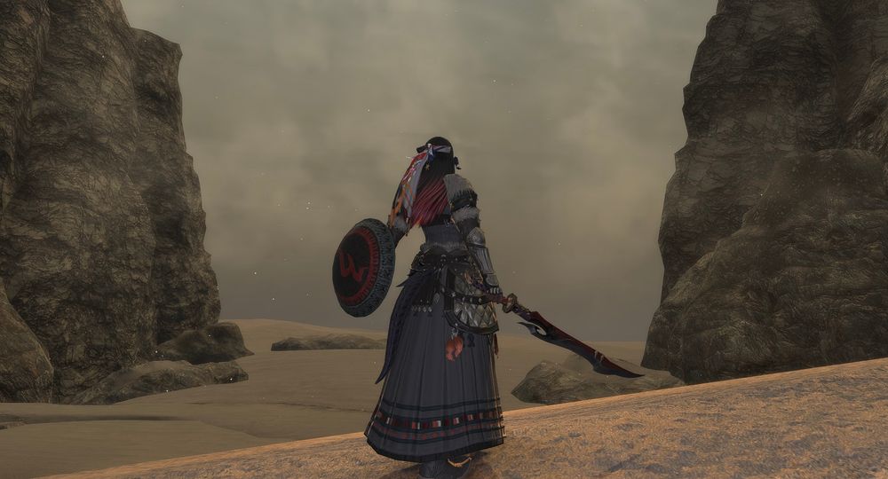 Taliya, in nomad fending armor, with lowered sword and Mol shield, stares out at a dust storm. Her back is to the camera as she prepares to walk in