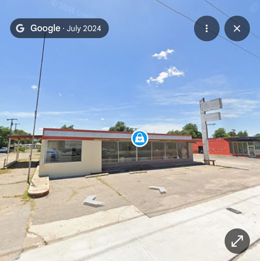 A Google street view of 3918 NW 10TH ST in OKC. It shows an old, closed single story building with a drive through and is white with red trim. 