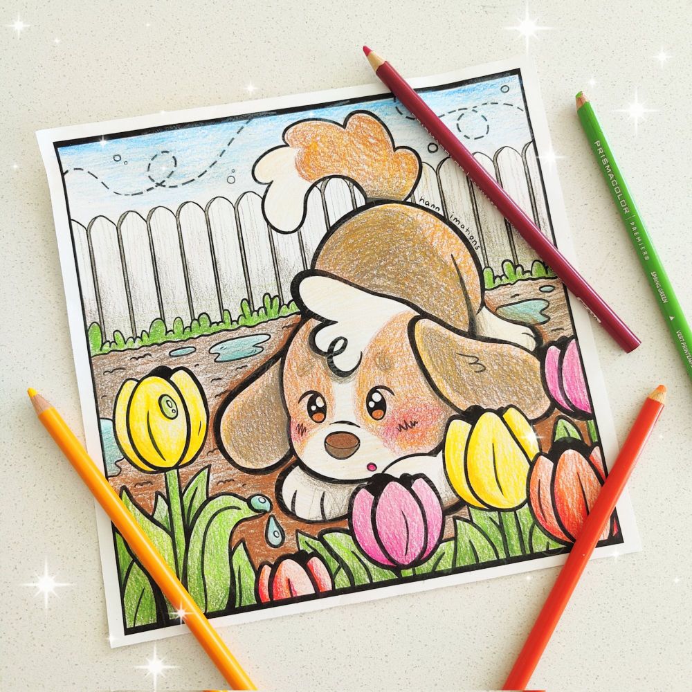 a picture of a colored coloring page, featuring a small floppy eared puppy looking at a tulip garden. surrounding the page there are a few colored pencils.