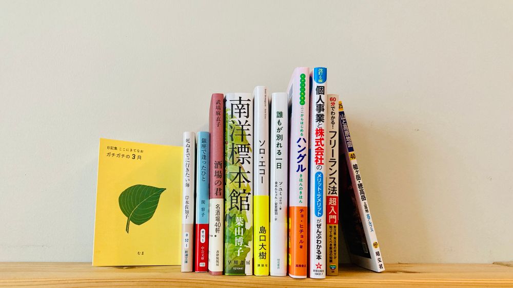 本棚に並んだ本とzine
「山と高原地図　槍ヶ岳・穂高岳」
「フリーランス法超入門」
「個人事業と株式会社のメリット・デメリット」
「ここからはじめるハングル」
『誰もが別れる一日』
『ソロ・エコー』
『南洋標本館』
『酒場の君』
『銀座で逢ったひと』
『死ぬまでに行きたい海』
「日記集 ここにきてなお」