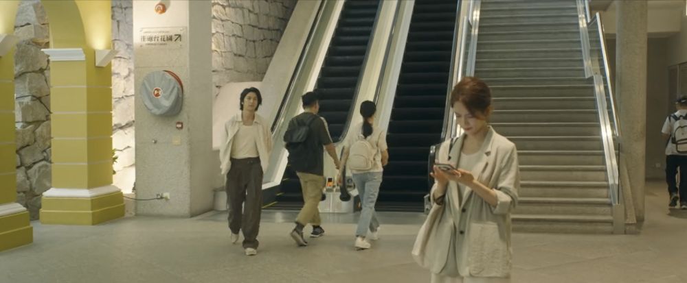 xu jun le walking towards mai you ge as she looks at her phone
