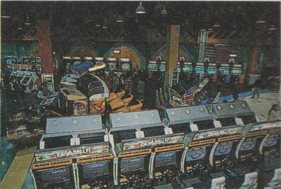 lots of racing games lined up (sega rally sit down cabs in the foreground).