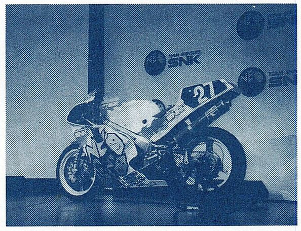 neo geo/snk branded motorcycle, displayed on a stage with the wall behind it displaying neo geo/snk logos.