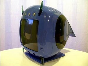 the tv is on a flat square stand. the tv itself is dark blue, very rounded.  it has 3 silver buttons above the screen and a small black aerial on each side. it has a "tail" at the back (that has some black on its sides). it looks sleek.