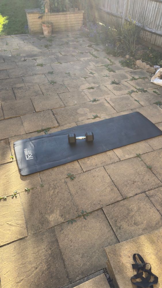 A fitness mat and dumbbell lying outside on the terrace 