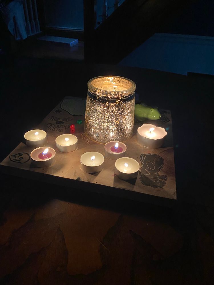 The “morning hearth” ritual. Instead of the green pillar candle and carefully placed items, there is a glittering scented candle surrounded by seven tea lights all “charging” in the energy we built while having a shared hot breakfast. (Bacon, eggs, hash browns, and griddle cakes)

Afterwards, these candles usually are moved (still burning!) to various rooms in the home to help warm and brighten against the chill spectres of winter. 

However, the ritual was cut short as I was about to move them. 