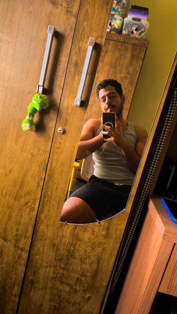 Um foto minha de frente a um espelho enquanto estou sentado em uma cadeira de escritório