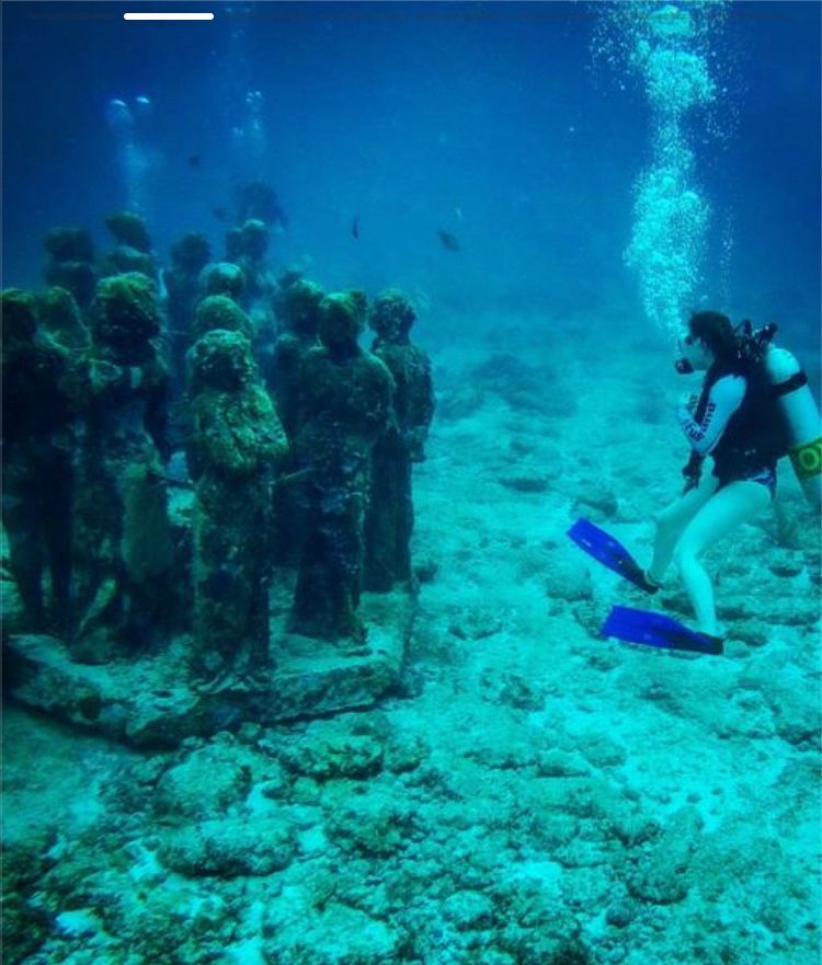 Scuba diving in front of some sunken statues
