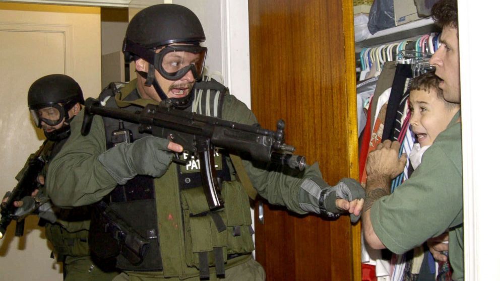 Elian Gonzalez being apprehended at gunpoint.