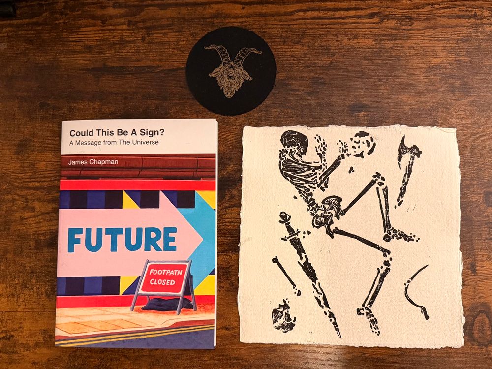 Could this Be a Sign? by James Chapman and a linocut print by Stish. There’s also a cool black patch with a gold goat’s head on it.