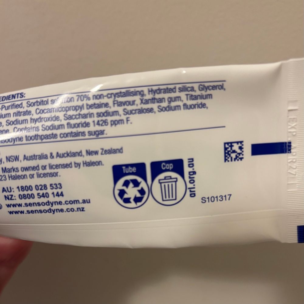 Sensodyne toothpaste tube showing the Australian recycling logos. The tube is recyclable, but the cap is to be thrown in the bin