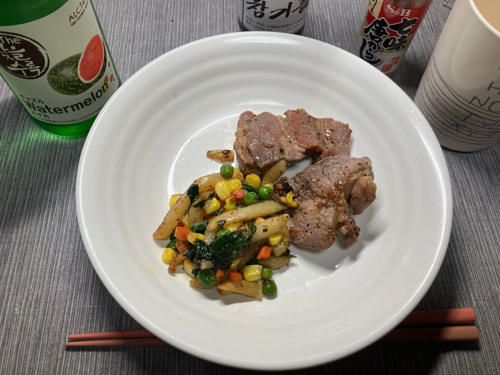 ポークソテーの写真。小さな厚切り肉をニンニク塩胡椒で。おつとめ品だけど焼けばうまい肉。付け合わせにミックスベジやフライドポテトや冷凍野菜の余りを残った脂で炒めた。取っといた찾을と食べた。