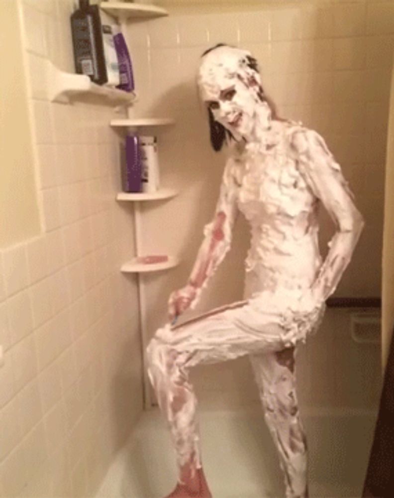 a woman covered in shaving cream in a shower