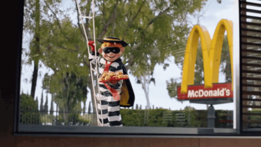 a mcdonald 's sign with a prisoner holding a ladder