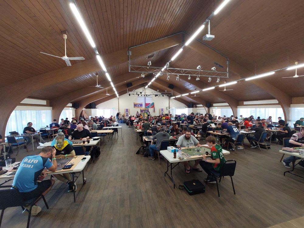 Supermarine sports club hall with ~130 mostly fat nerds in pairs pretending they're the coaches of American football teams with fantasy creatures in.