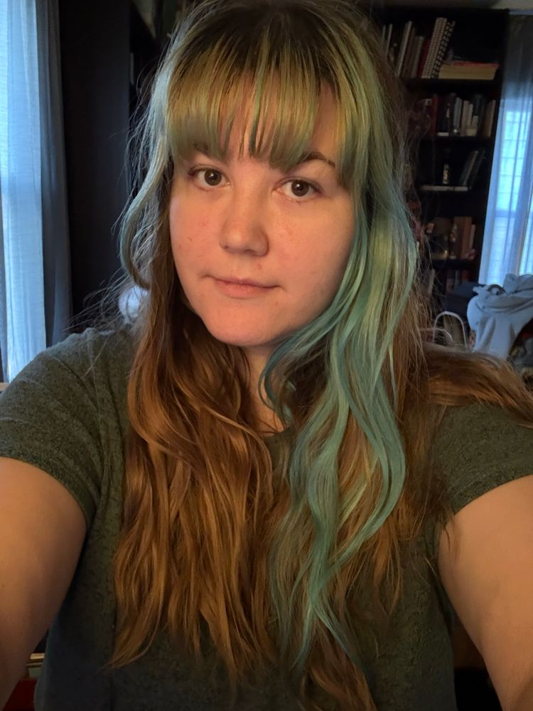 A selfie of an exhausted woman with long hair. It’s nipple length. I’m sorry but I don’t know how else to describe it 