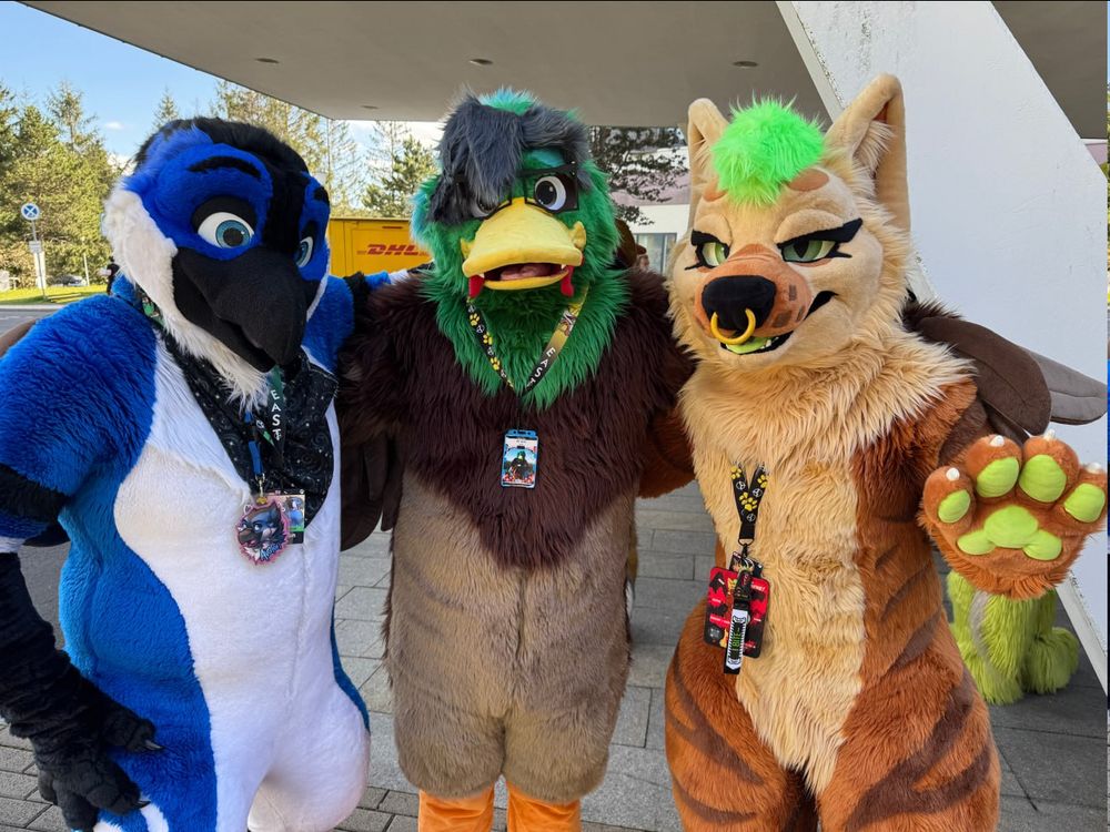 three fursuiters, a blue jay, a duck and a hyena posing for the camera