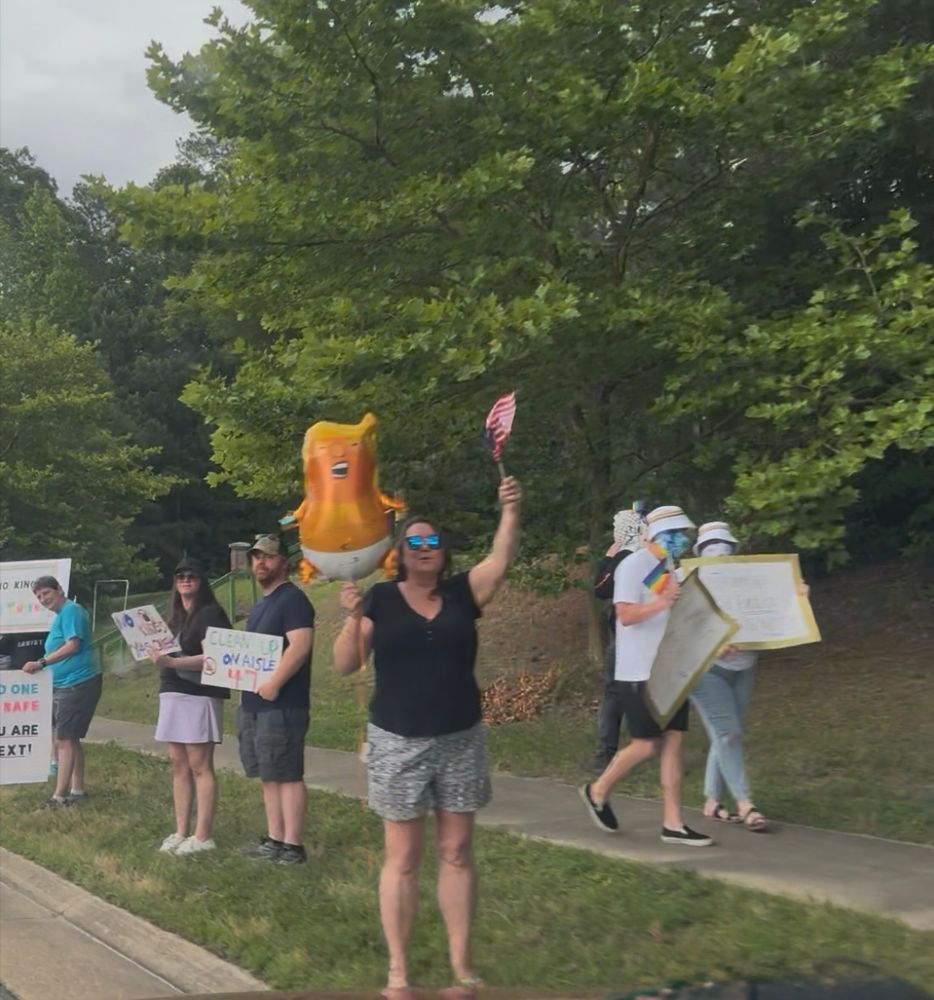 Williamsburg, VA No Kings protesters with signs and flags