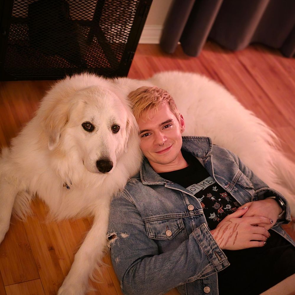 photo of me laying my head on Arya, a big floofy great pyrenees while we both look at the camera