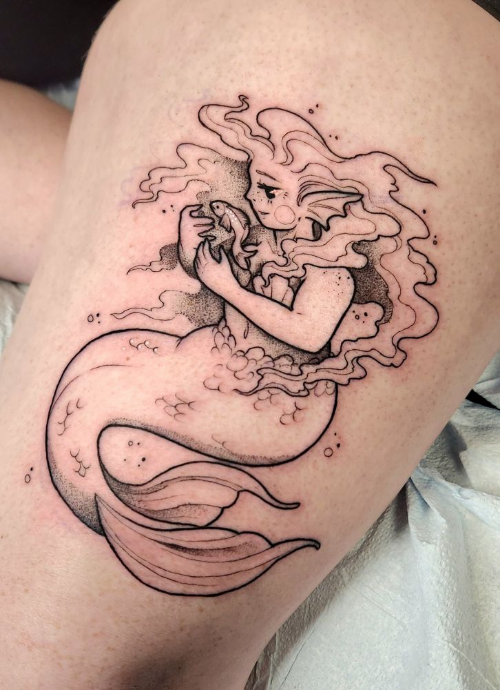 Blackwork tattoo of a mermaid in a sitting position, hands cupped around a swimming fish