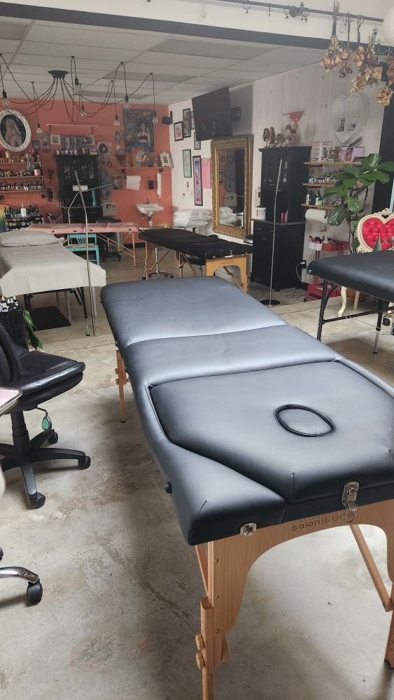 The view from inside the shop! Tattoo beds, a pink wall filled with knick knacks, and plants!