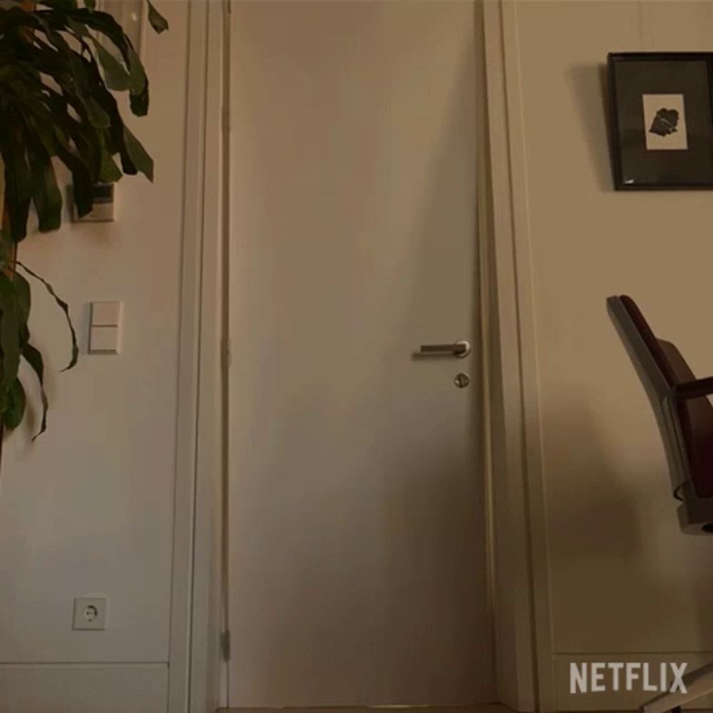 two people in yellow jumpsuits are standing in a hallway with a netflix logo behind them