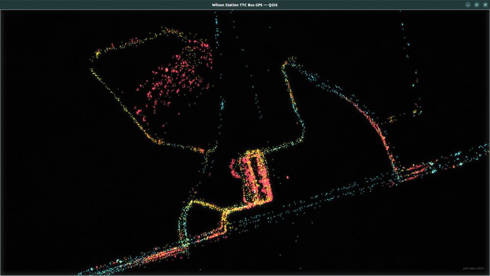 A bunch of blue, yellow, and red points on a black background. The points represent GPS pings of one day of buses in Toronto around Wilson Station. The points cluster and visually represent streets, driveways, and bus bays.