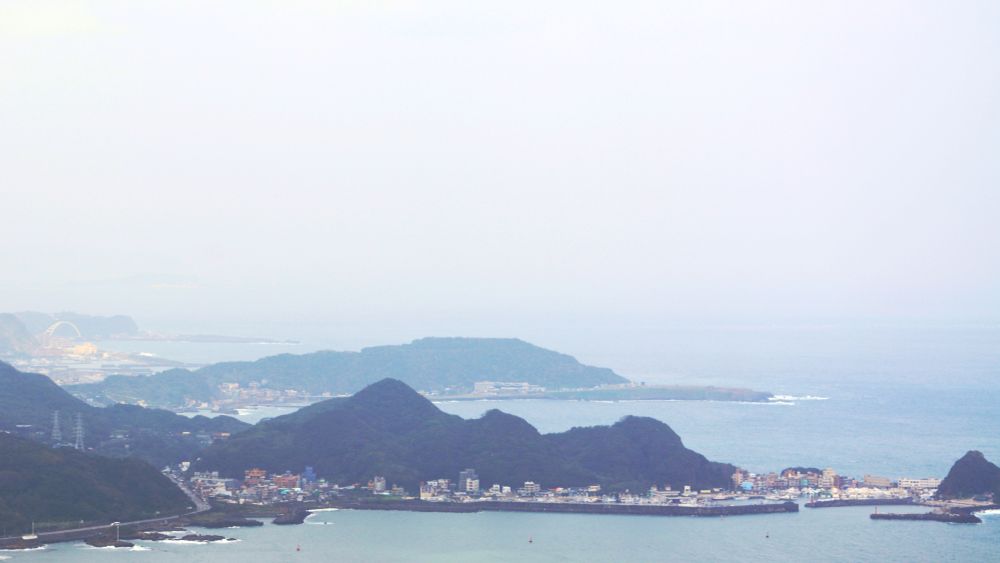 Photo of northern coast of Taiwan in 02/2025. Cities and green hills and open water.