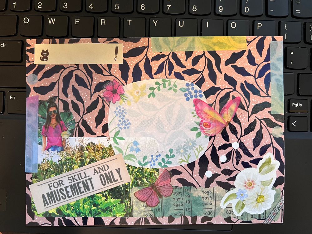 Collaged envelope. Background paper with dark leaves, midori notepaper as the label, pink flower and butterflies. Rainbow tape, white flowers and a cat return address label.