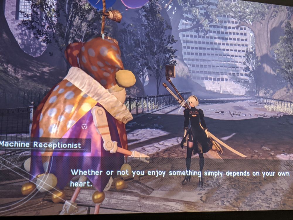 A screenshot from the game Nier:Automata. An NPC named Machine Receptionist says: "Whether or not you enjoy something simply depends on your own heart."