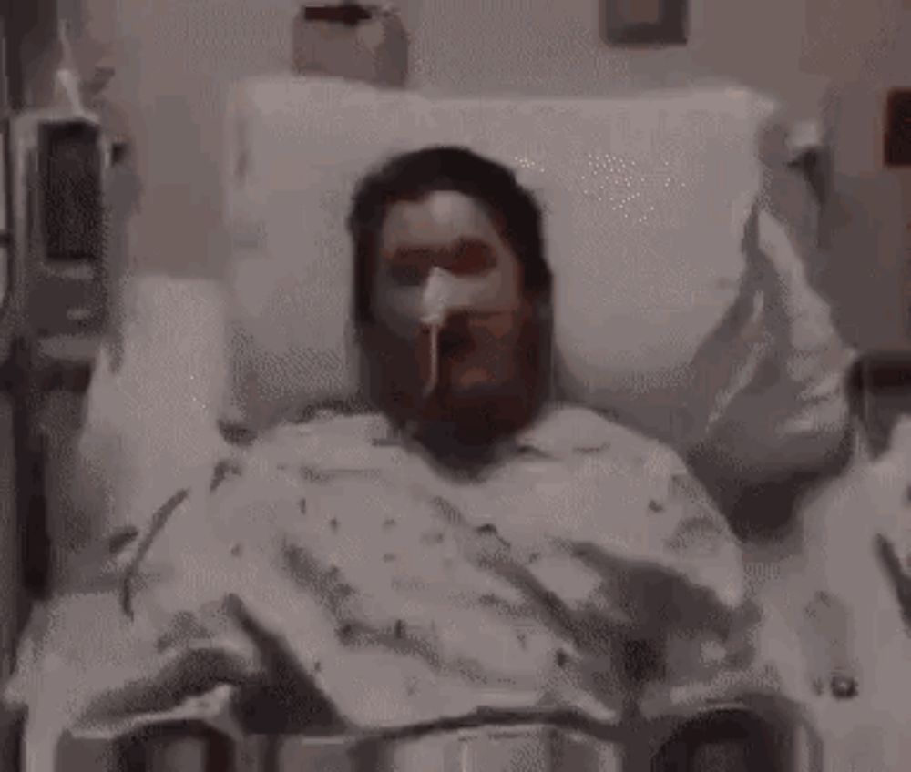 a woman is laying in a hospital bed with an oxygen mask on .