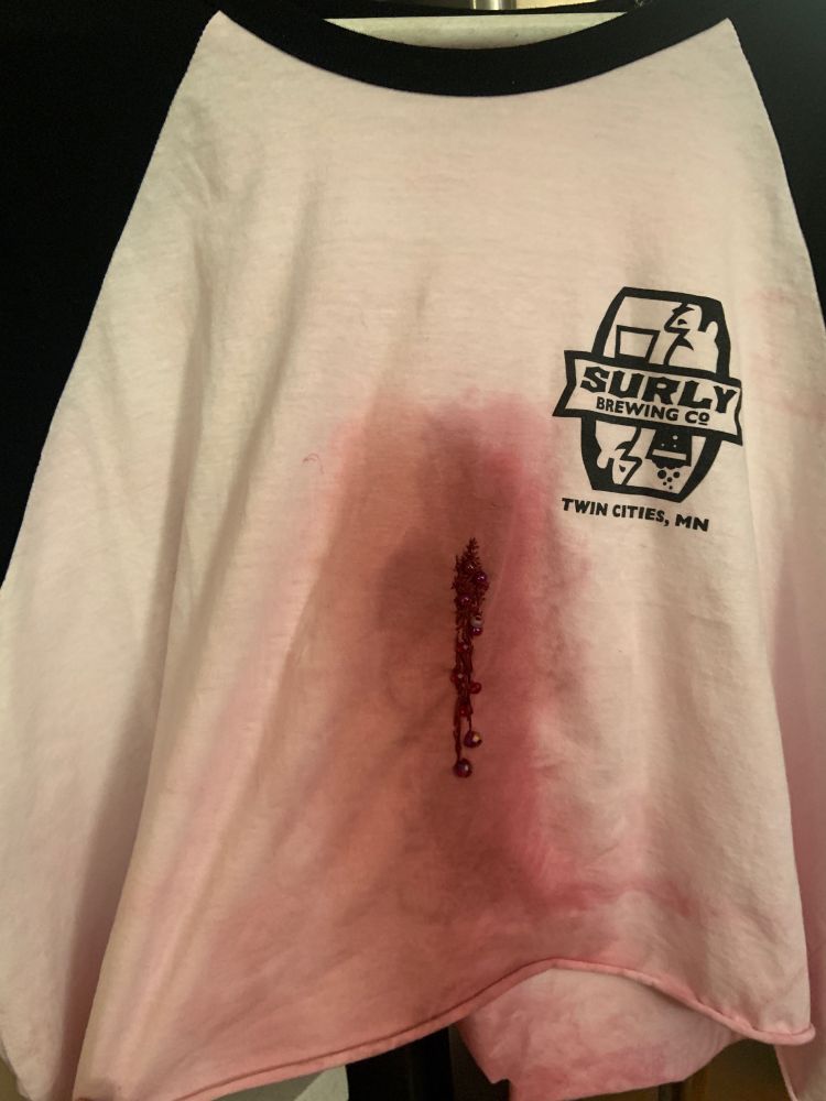A cropped raglan shirt with red dye, embroidery, and beading to mimic a bloodstain