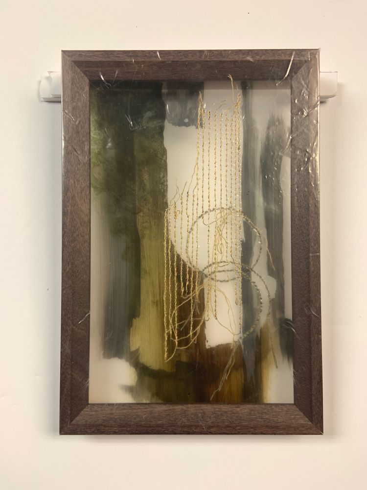 A purple brown frame wrapped in layered plastic. The plastic is painted in browns and greens with vertical and circular stitching throughout.