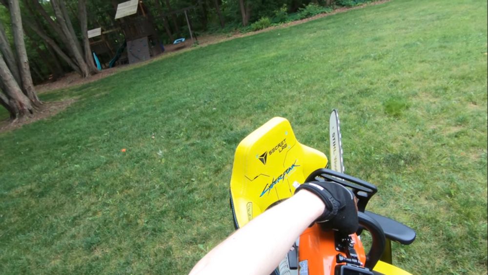 first person view of someone taking a chainsaw to a Cyberpunk 2077 gamer chair