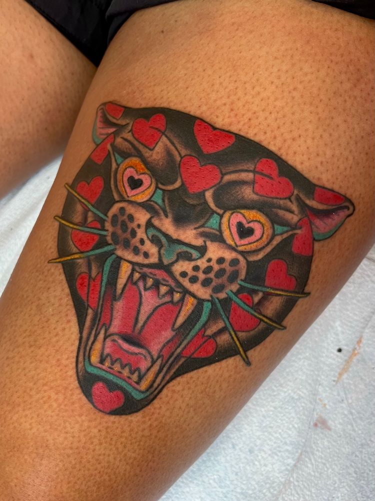 Traditional tattoo of a panther covered in hearts